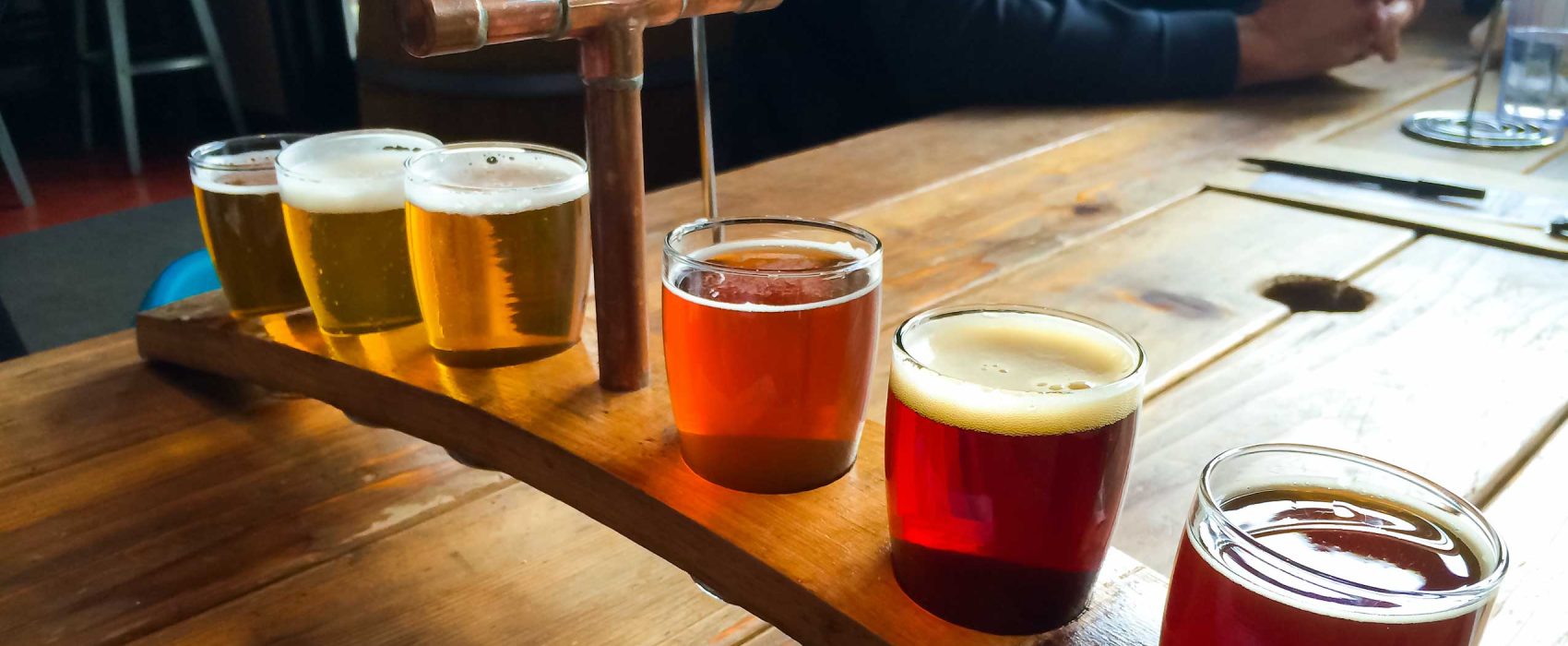 Wooden Tray Holding 6 Different Types Of Beers
