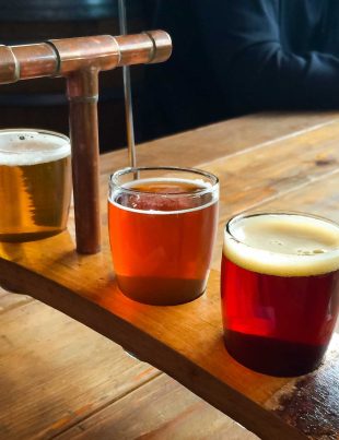 Wooden Tray Holding 6 Different Types Of Beers