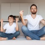 Father And Son Meditating In Kitchen