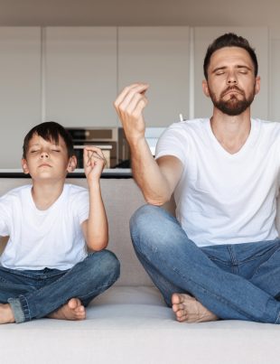 Father And Son Meditating In Kitchen