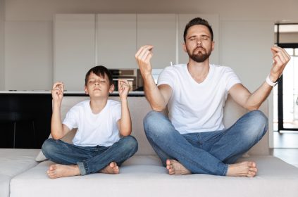 Father And Son Meditating In Kitchen