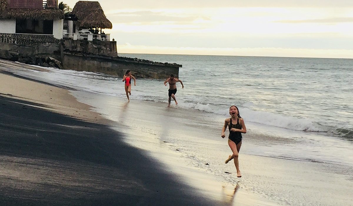 Mikhail Pimenov Running On Beach With His 2 Daughters Behind Him