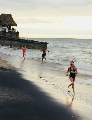 Mikhail Pimenov Running On Beach With His 2 Daughters Behind Him