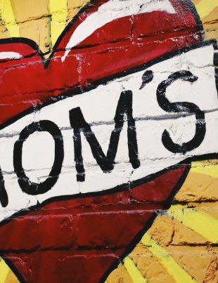 Heart With Word MOMs Across Heart Painted On Brick Wall