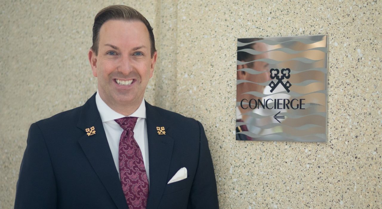 Robert Marks Chef Concierge Of Omni Hotel San Diego Standing Next to Clefs D'Or International Sign