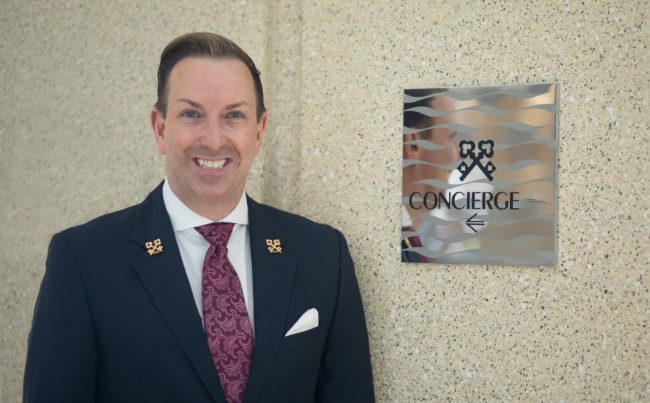 Robert Marks Chef Concierge Of Omni Hotel San Diego Standing Next to Clefs D'Or International Sign